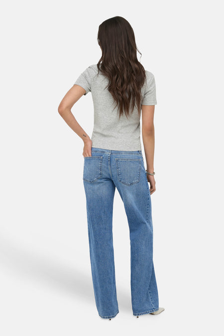 Grijs T-shirt van ONLY®, met korte mouwen en geribbelde textuur, gedragen door een model van achteren met blauwe jeans.
