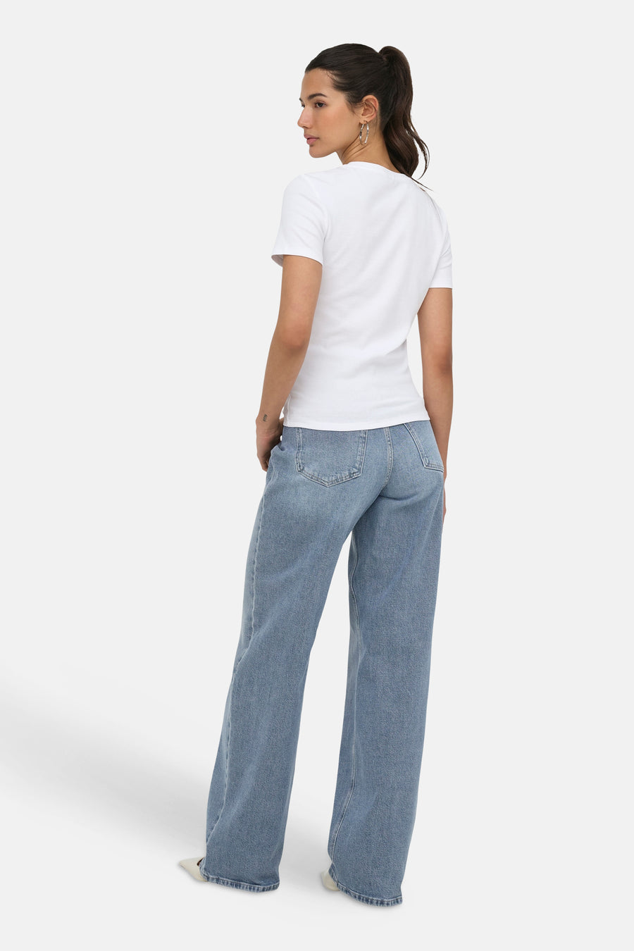 Witte korte mouwen t-shirt van ONLY®, achterzijde, strakke pasvorm, gedragen met lichtblauwe wijde jeans