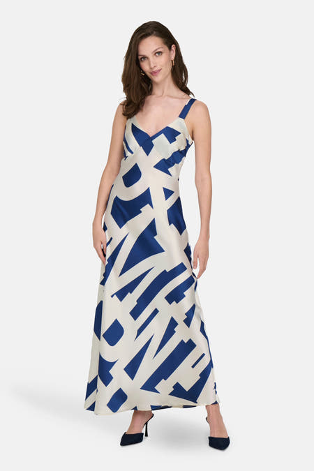Mouwwloze blauwe jurk van ONLY, met een grafisch wit en blauw patroon en hakken.
