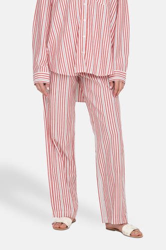 Rode broek van ONLY® met witte strepen, gedragen met een gestreepte blouse en witte sandalen.
