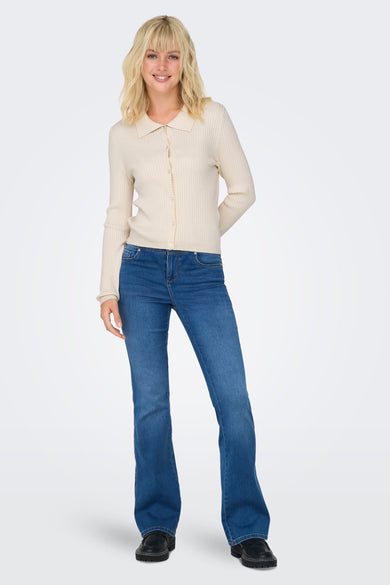 Ecru gebreide pull van ONLY, met lange mouwen, gedragen met blauwe jeans en zwarte schoenen.