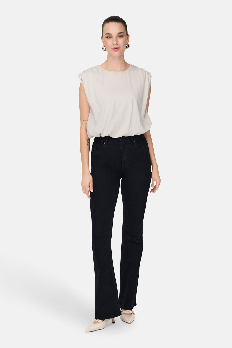Witte mouwloze top van JDY, met afgeronde halslijn en gecombineerd met zwarte jeans en pumps.