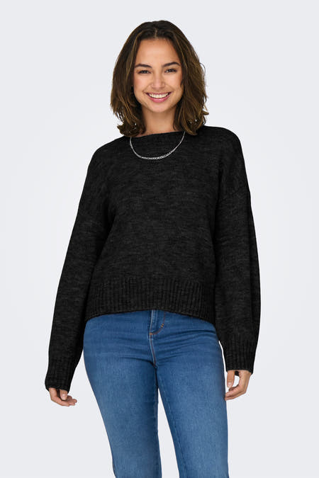 Pull noir avec col rond de ONLY, accompagné d'une chaîne argentée et de jeans bleus.