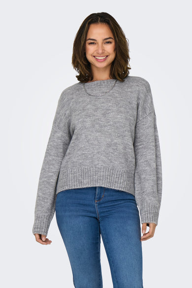 Sweat-shirt gris à col rond ONLY, avec des manches longues, associé à un jean bleu et une chaîne argentée.