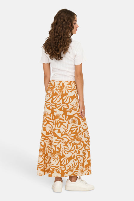 Pantalon orange long de ONLY, avec un motif floral crème et associé à une chemise blanche et des baskets.