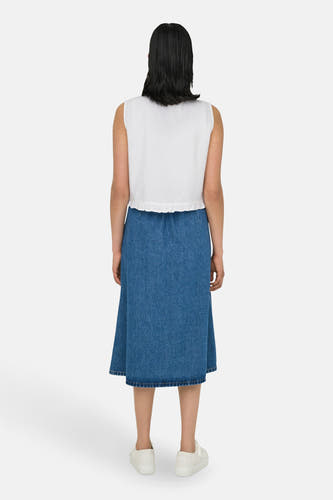 Witte mouwloze blouse van ONLY, met een geplooide zoom en verder gecombineerd met een denim rok en witte sneakers.
