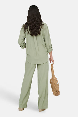 Groen overhemd met lange mouwen van JDY, gedragen met bijpassende broek, van achteren gezien, met een geweven tas.
