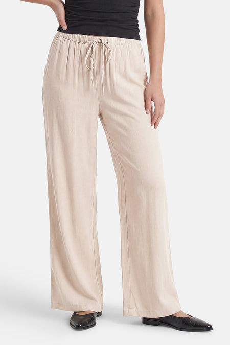 Ecru broek van JDY met elastische taille, trekkoord en wijde pijpen, gedragen met een zwarte top en schoenen.