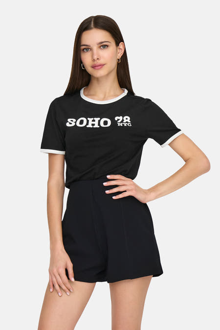 Zwart T-shirt met korte mouwen van ONLY, met witte randen en opdruk; gedragen met zwarte short.
