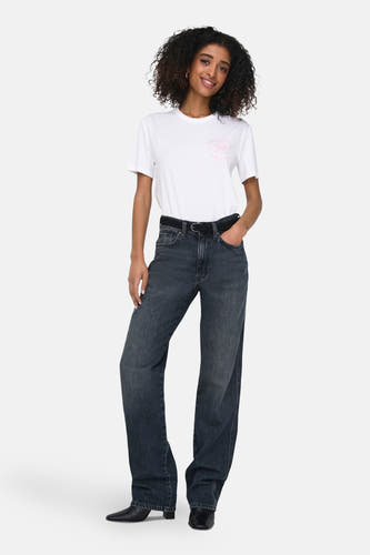 T-shirt blanc à manches courtes d'ONLY, avec une impression rose et porté avec des jeans larges et des bottines noires.