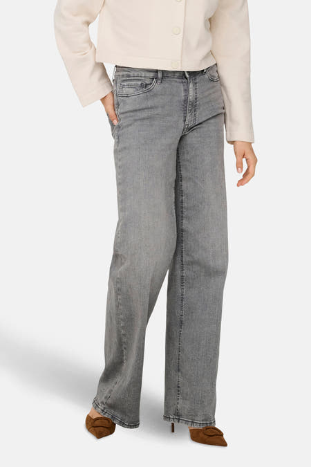 Lichtgrijze wide jeans van JDY, gecombineerd met een crèmekleurige blouse en bruine schoenen.