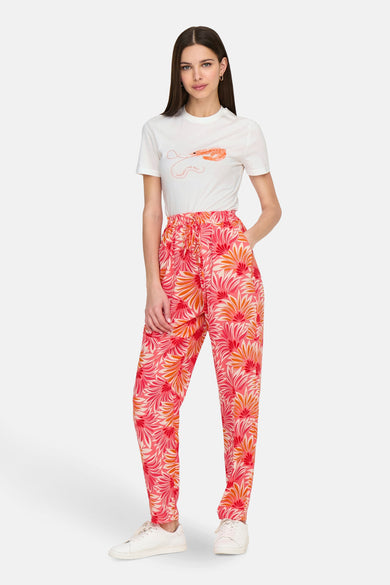 T-shirt blanc à manches courtes de ONLY®, avec une impression d'un crevette et du texte, associé à un short rose avec imprimé fleurs.