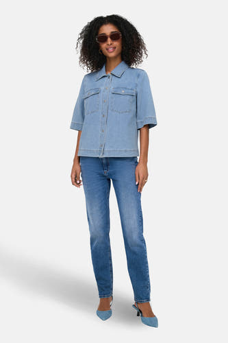 Lichtblauw denim hemd met korte mouwen van ONLY, met borstzakken en gedragen met jeans en blauwe hakken.
