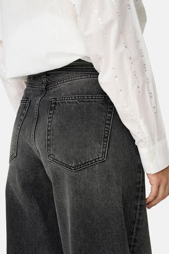 Donkergrijze rechte jeans van ONLY, met zichtbare achterzakken en een wit overhemd met pailletten.
