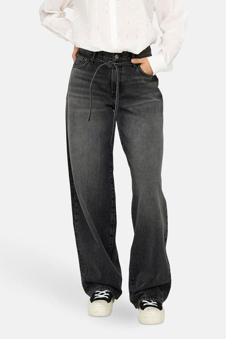 Grijze straight jeans van ONLY, met strikkoord in de taille, gedragen met een witte blouse en sneakers.
