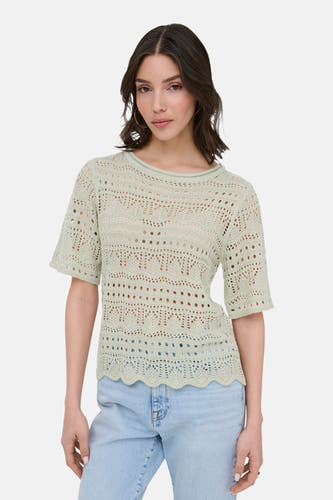Pull vert à col rond de JDY, avec tricot ajour ouvert et jean bleu clair.