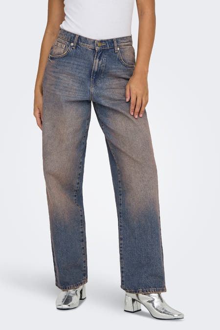 Donkerblauwe boyfriend jeans van ONLY, met bruine wassing, gedragen met een witte top en zilveren laarzen.
