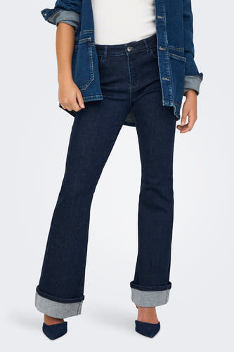 Jean flare bleu marine d'ONLY, avec des poches rabattues et associé à une veste en cuir.
