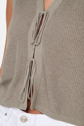 T-shirt sans manches beige ONLY, avec une fermeture à col roulé et une texture côtelée, porté sur un pantalon blanc.