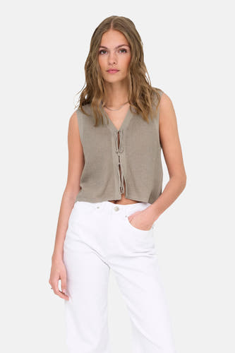 Top beige sans manches ONLY, avec un détail boutonné et porté avec une jupe blanche.