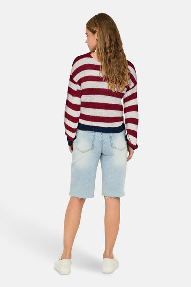 Gestreept gebreide trui met V-hals van ONLY, verder afgewerkt met lichtblauwe denim shorts en witte schoenen.