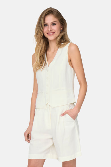 Witte blazer van ONLY, met korte broek en vest gedragen door een lachende vrouw.