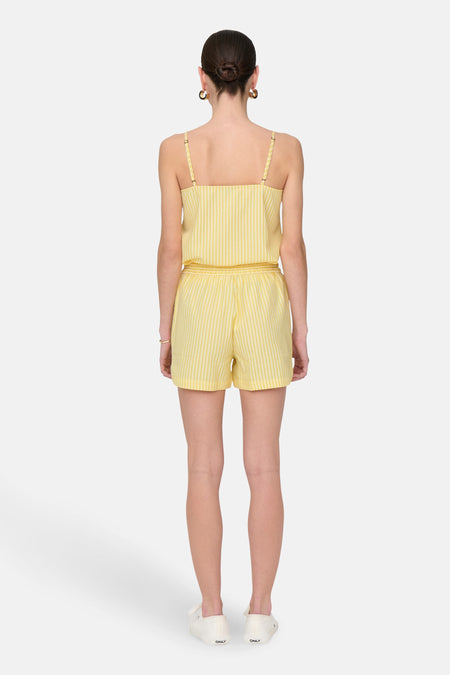 Short rayé jaune de JDY, avec une chemise coordonnée et des baskets blanches.
