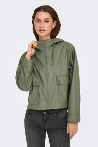 Kakikleurige regenjas van ONLY, met capuchon, zakken met knoopsluiting en gedragen over een donkere jeans.
