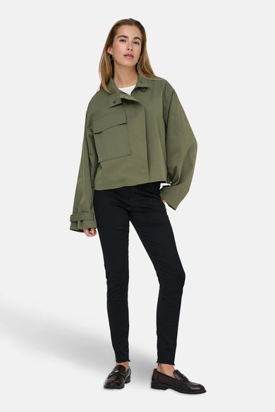 Groene korte jas van ONLY, met lange mouwen, gedragen over een wit shirt en een zwarte broek.
