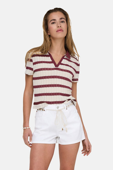 Ecru polo met korte mouwen van ONLY, met rode strepen en gedragen met witte shorts met schelpenriem.
