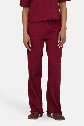 Bordeaux broek van ONLY, met een geplooide textuur en uitlopende pijpen.