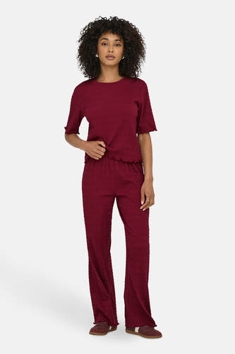 Bordeaux broek van ONLY, met een geribbelde textuur en losse pijpen, gecombineerd met een bijpassende top.