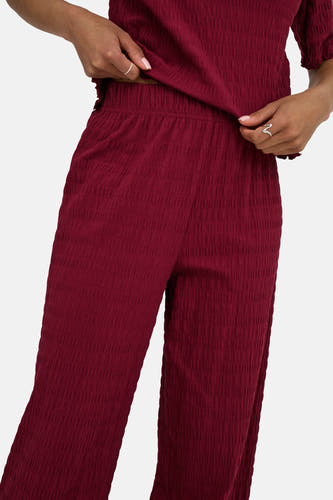 Bordeaux broek van ONLY, met een geplooide textuur en wijde pijpen.
