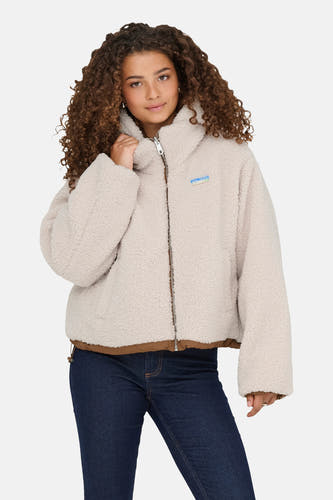 Ecru korte jas van ONLY, met ritssluiting en donkerblauwe jeans.
