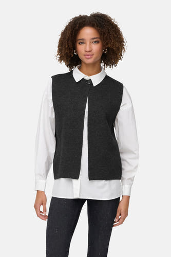 Grijs vest van ONLY, gedragen over een wit overhemd en donkere broek met stippen.

