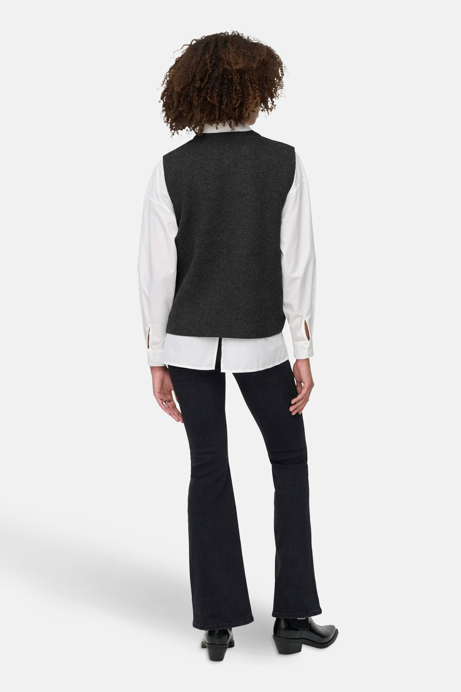 Grijs vest van ONLY, gedragen over een wit overhemd met donkere spijkerbroek en zwarte laarzen.
