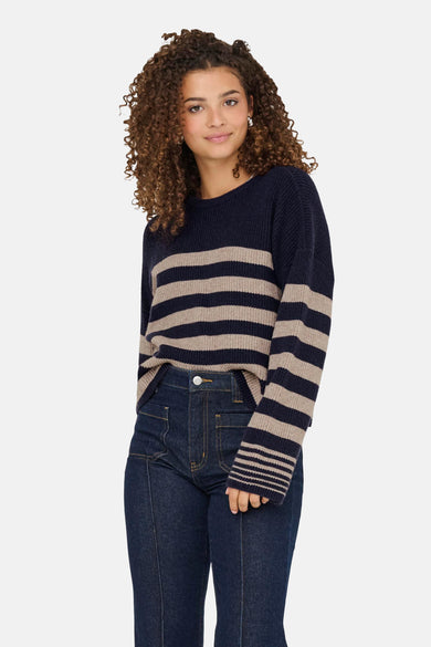 Blauwe trui met ronde hals van ONLY, met beige strepen en donkere jeans.

