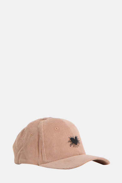 Beige pet van ONLY® met corduroy textuur en een zwarte hart applicatie, gezien vanaf de zijkant.
