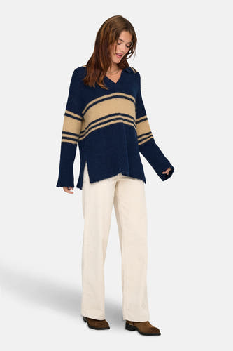 Blauwe trui van ONLY® met beige strepen, gedragen met een witte broek en bruine laarzen.