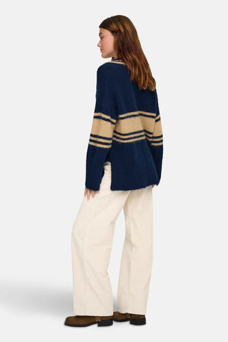 Blauwe gestreepte trui van ONLY®, met lange mouwen, gedragen met een crèmekleurige corduroy broek en bruine laarzen.
