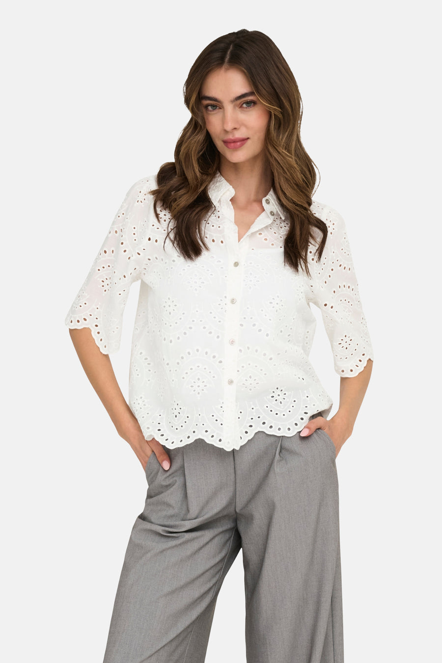 Chemise blanche ONLY avec détails brodés, portée avec un pantalon gris et des sandales noires.