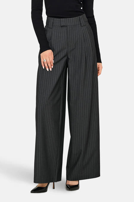 Grijze broek van ONLY® met krijtstreep, gecombineerd met een zwarte top en hakken.