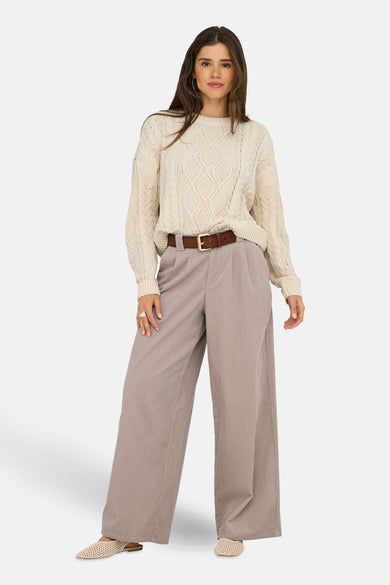 T-shirt écru avec col rond de ONLY, à motif côtelé et porté avec un pantalon taupe et une ceinture marron.