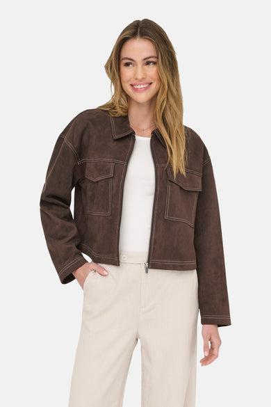 Bruine korte jas van ONLY, met contrasterende stiksels en gedragen over een wit shirt en beige broek.
