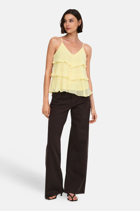Gele mouwloze blouse met ruches van ONLY®, gedragen met donkere wijde broek en sandalen, front view