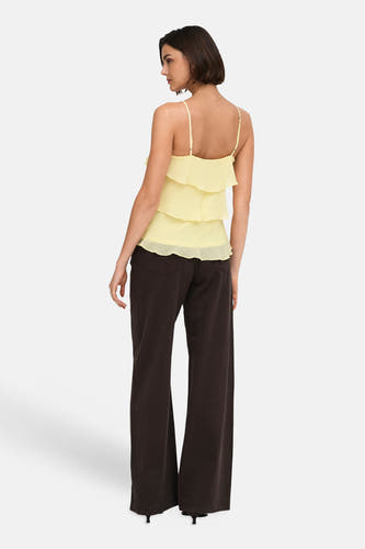 Gele mouwloze blouse met ruches van ONLY®, achterzijde weergegeven, lichte stof, dunne bandjes, model draagt donkere wijde broek
