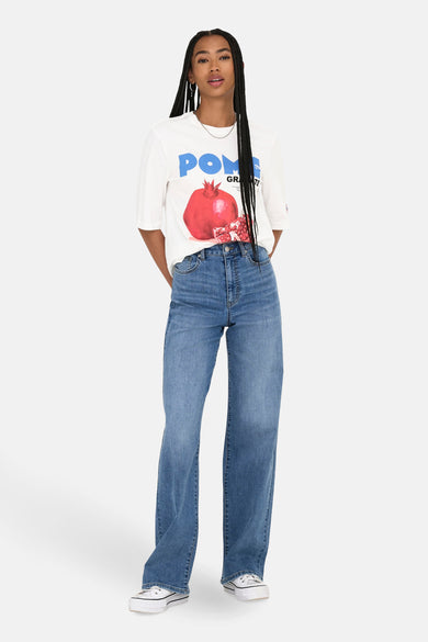 Wit T-shirt met korte mouwen van ONLY, met een granaatappelprint, gecombineerd met wijde jeans en witte sneakers.
