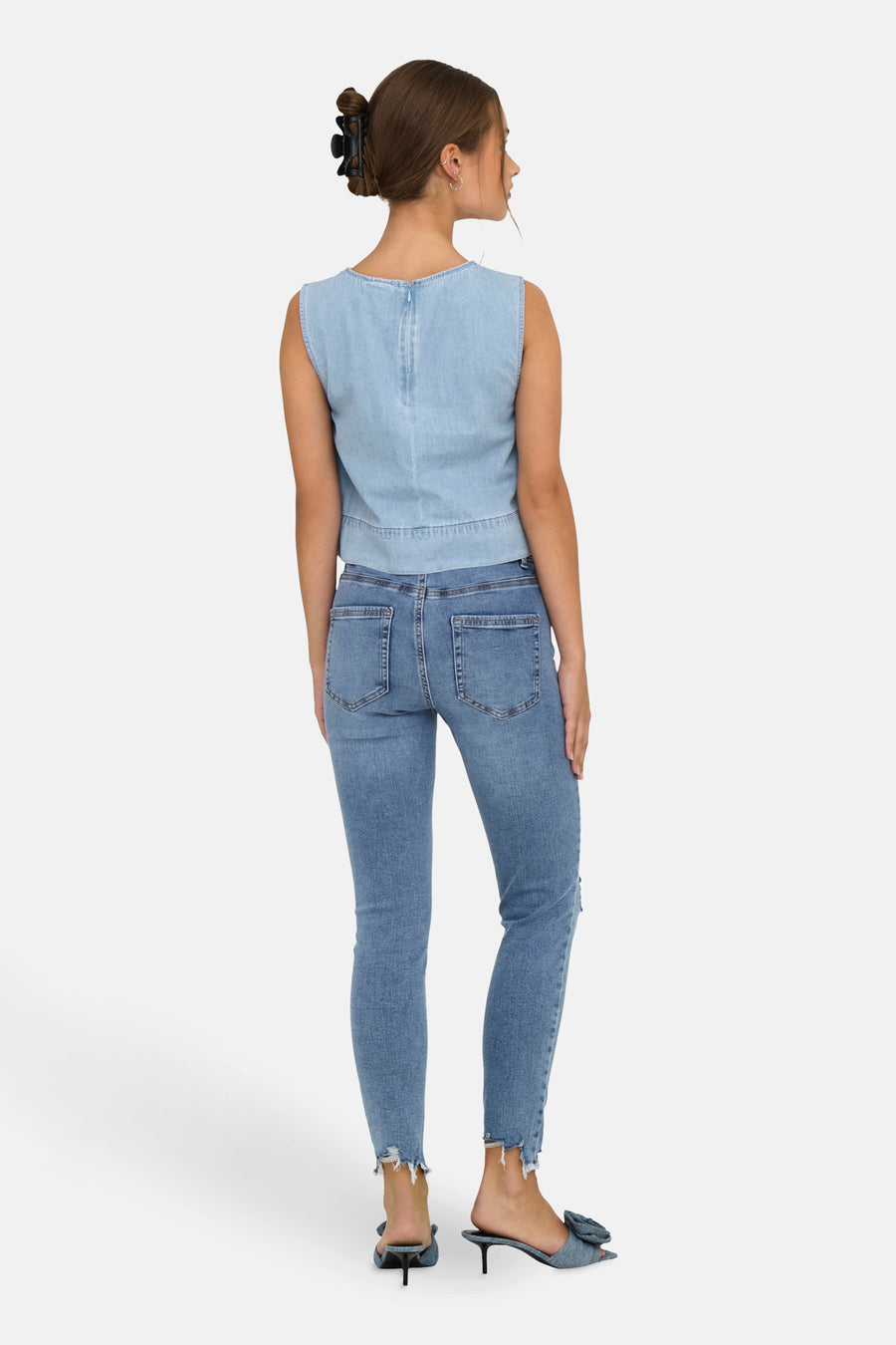 Vrouw van achteren in spijkerbroek en denim top.