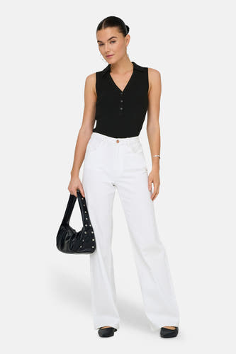 Haut noir sans manches de JDY, avec fermeture à boutons et porté avec un pantalon blanc et un sac noir.