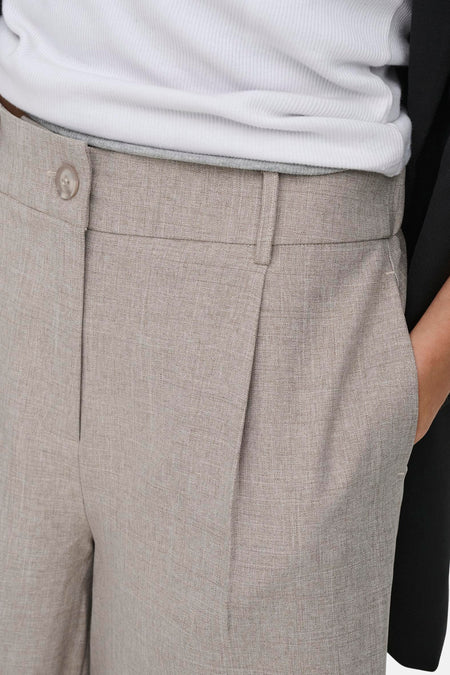Beige short van ONLY® met linnenachtige textuur, knoopsluiting en plooien, gedragen met een witte geribde top en zwarte blazer.